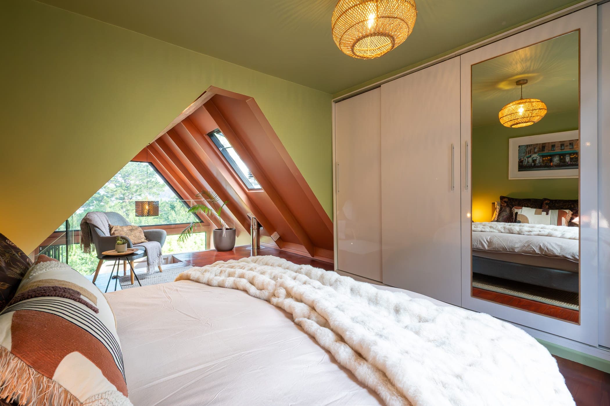 The bed with its mirrored wardrobe reflecting the room and the nook