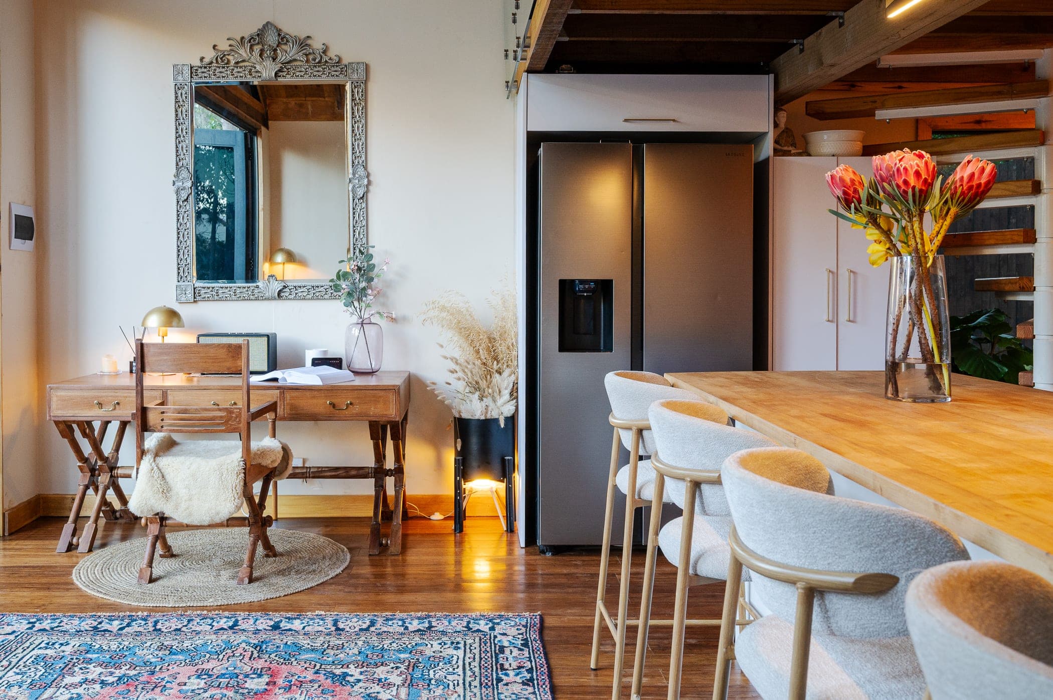 The desk nook and its carved mirror, beside the island and the fridge