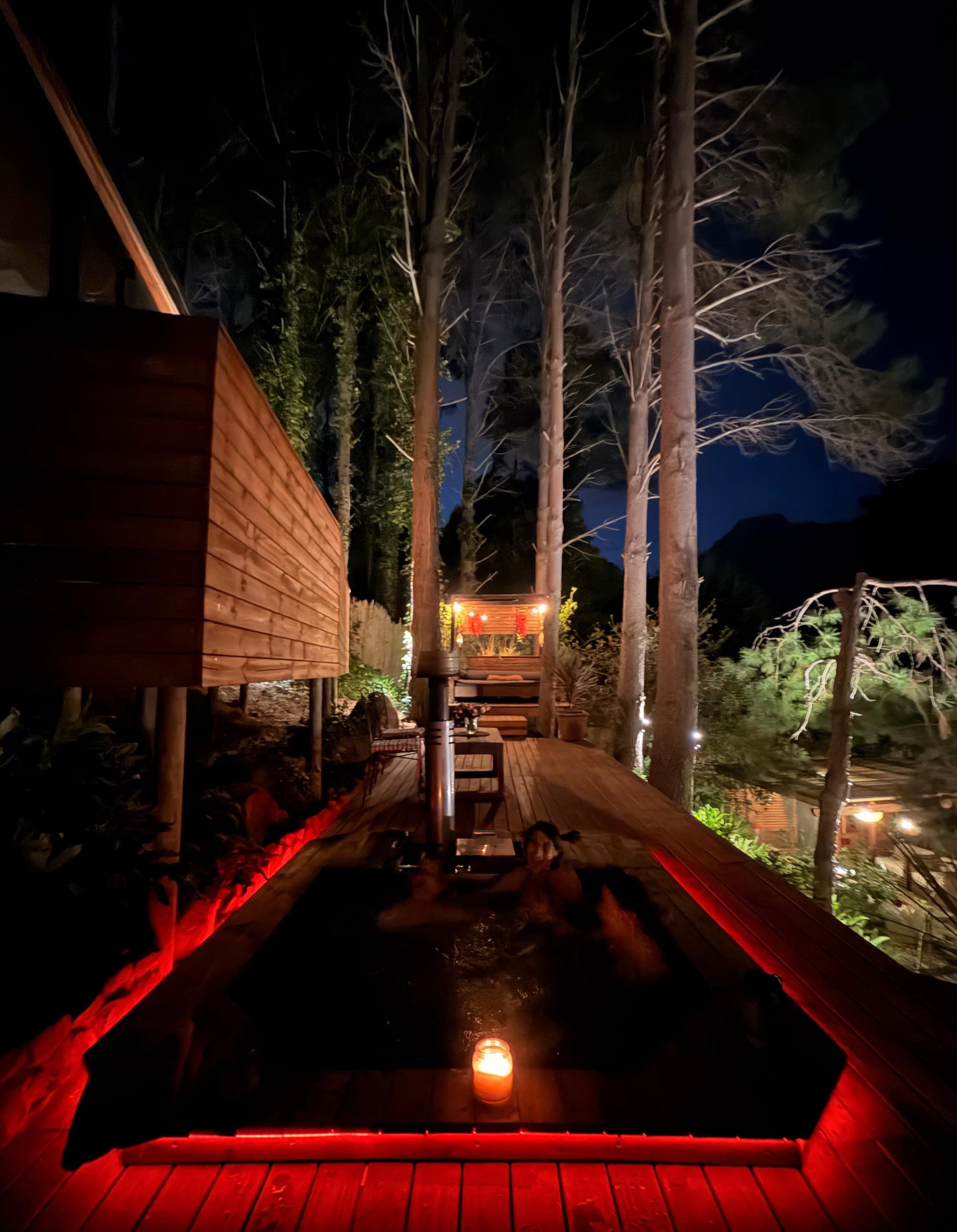 The hot tub set into the upper deck, the pool and pergola below