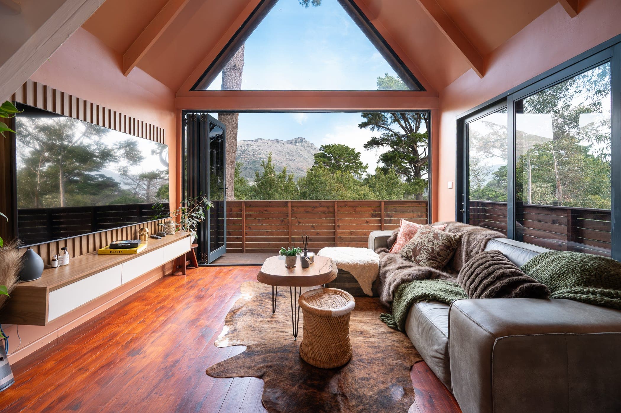 The living room with the bifolds folded right back, the Hout Bay mountains straight ahead