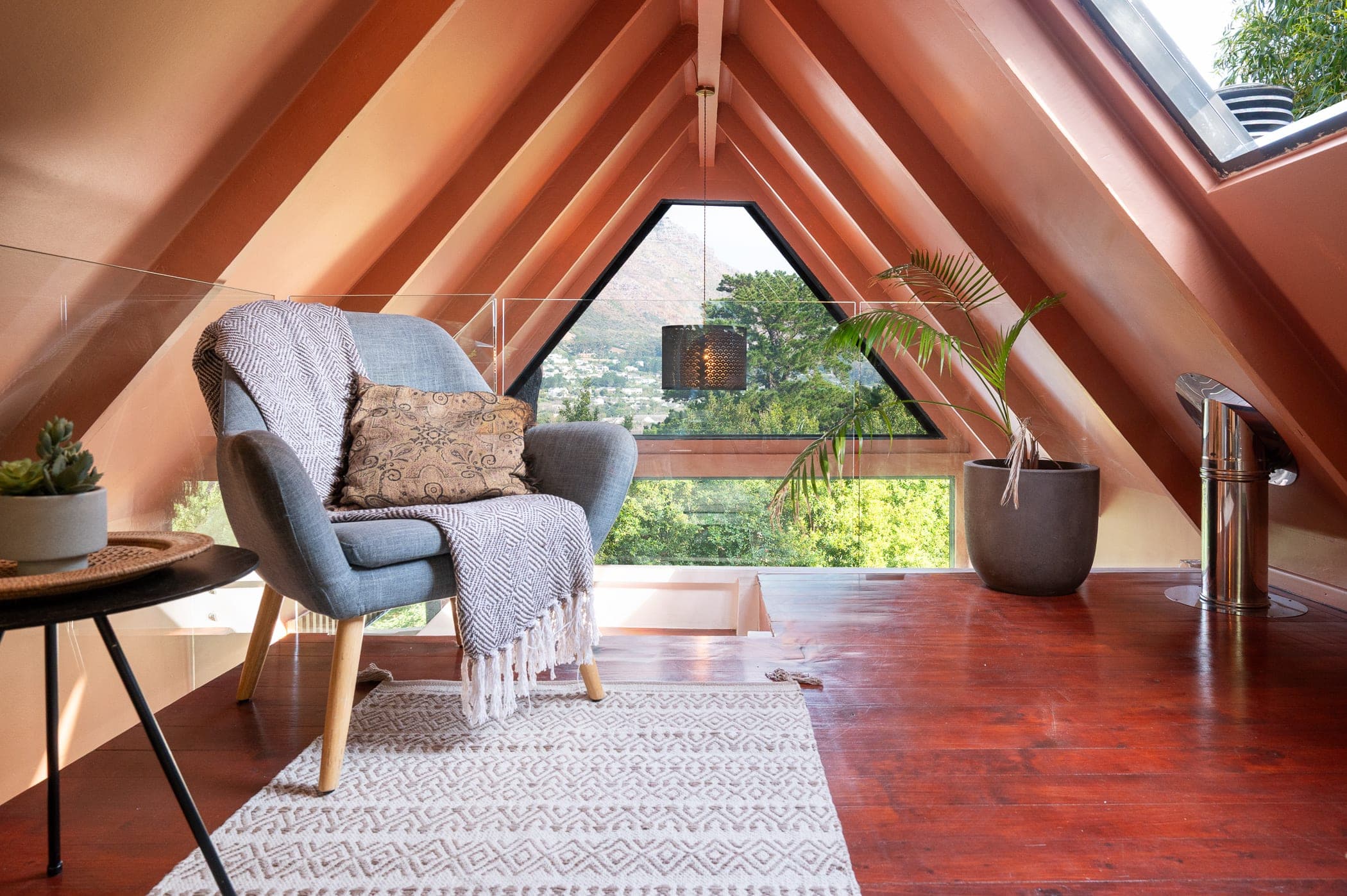 The reading nook in the gable, armchair framed by the triangular window and mountain